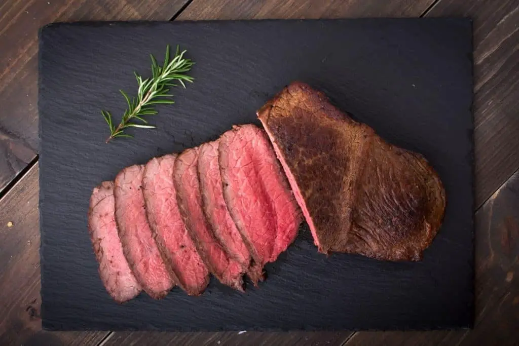 Roast beef on a black cutting board